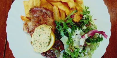Schweinesteak mit Kruterbutter SteakhousePommes und Salat